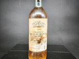 une photo d'une bouteille de vin posée sur une table noire