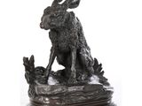 une statue représentant un lapin assis sur un socle en bois