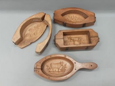 three wooden spoons and a wooden spoon with carvings of animals on them