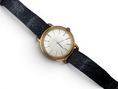 une image d'un gros plan d'une montre-bracelet sur une surface blanche
