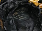 a close up of a black hat with yellow flowers around it