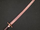 un couteau avec un manche en bois posé sur une surface noire