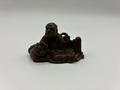 une petite statue représentant un homme assis sur une table