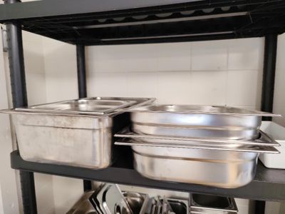 de nombreuses casseroles et poêles sur l'étagère de la cuisine