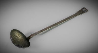 a close up of a spoon with a handle on a white surface