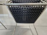a metal chair that has a basket on top of it