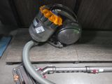 un aspirateur posé sur le sol à côté d'un tuyau
