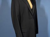 a black suit on a mannequin stand against a blue background