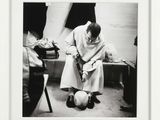 a black and white photo of a man kneeling down with a ball
