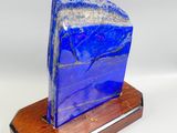 a blue stone on a wooden stand on a white background
