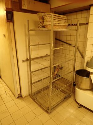 une cuisine équipée d'une étagère métallique et d'une cuisinière blanche