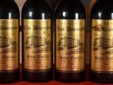 three bottles of red wine are lined up on a table