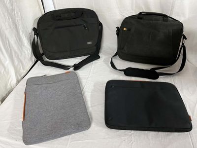 three laptop bags sitting on a bed next to each other