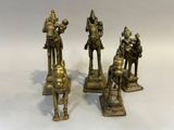 trois figurines en bronze représentant un homme et une femme à cheval