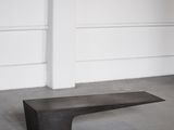 un gros plan sur un banc en bois dans une pièce aux murs blancs