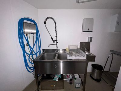un évier en acier inoxydable avec un robinet dans un coin de la pièce