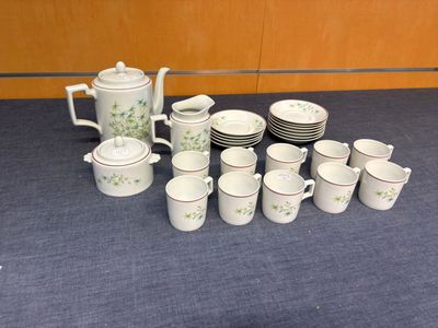 un grand nombre de tasses et de soucoupes sur une table