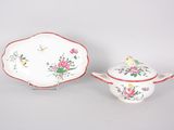 two pieces of china with flowers and birds on them on a table