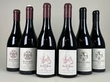 six bouteilles de vin sont alignées sur une table