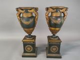 pair of antique green and gold vases on pedestals against a white background