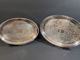 two silver trays sitting on top of a table next to each other