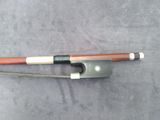 a close up of a violin bow on a gray surface