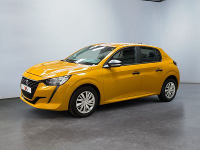 Une voiture jaune est garée dans une pièce aux murs blancs.