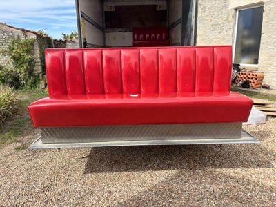 a red couch that is in the back of a truck