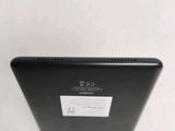 the back of a black tablet computer sitting on top of a white table