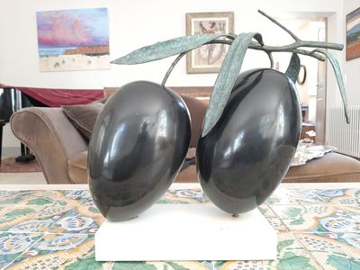 deux aubergines noires posées sur un support blanc