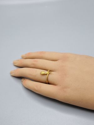 la main d'une femme portant une bague en or au doigt