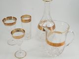trois verres et une carafe posés sur une surface blanche
