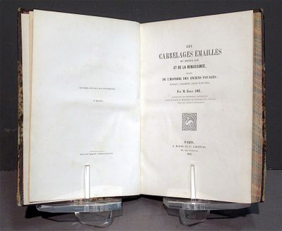 deux livres ouverts posés sur une table, avec des verres dessus