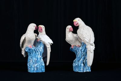 Paire de couples de perruches branchées en faïence émaillée.