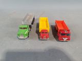 three toy trucks sitting next to each other on a table