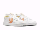les baskets blanches et orange sont posées sur une surface blanche