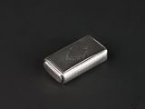an image of a silver cigarette case on a black surface