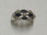 a silver ring with black and white stones on it