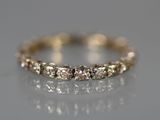 un gros plan d'une bague en diamant posée sur une surface réfléchissante