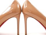 pair of women ' s nude colored high heeled shoes on a white surface