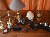 a wooden table topped with a lamp, a clock and other items