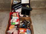 une boîte en carton posée par terre et remplie de toutes sortes d'objets
