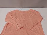 the shirt is pink and has a long sleeve on it