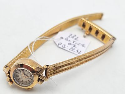 an image of a gold wrist watch with a chain around it