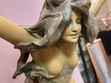 a statue of a woman holding a clock in her hand