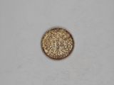 a close up of a gold coin on a white surface