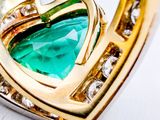 a green stone in the shape of a heart on a gold plated necklace