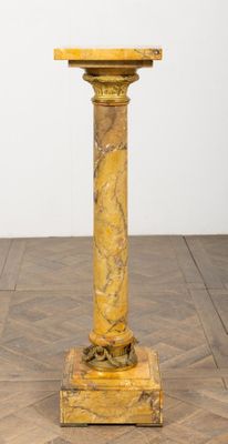 an image of a marble pedestal on a parquet floor