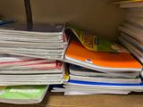 a stack of books sitting on a desk next to a pile of papers