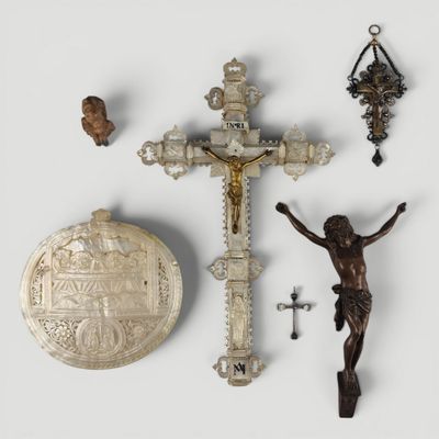 un crucifix, une croix et d'autres objets religieux posés sur une surface blanche